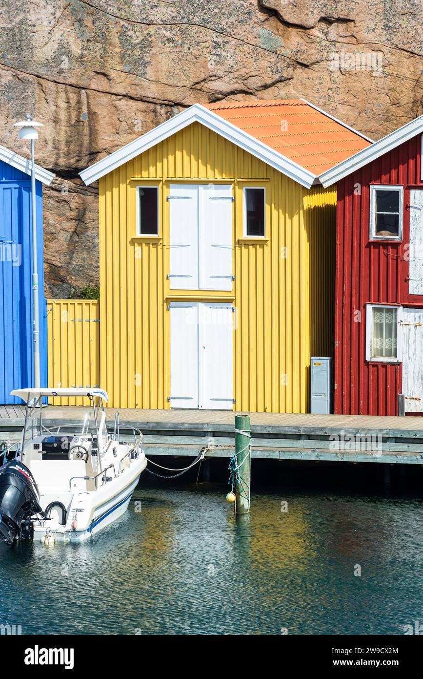 Magazzino con facciata in legno giallo davanti a rocce di granito sul lungomare del porto di Smögen, nell'arcipelago della costa occidentale svedese Foto Stock