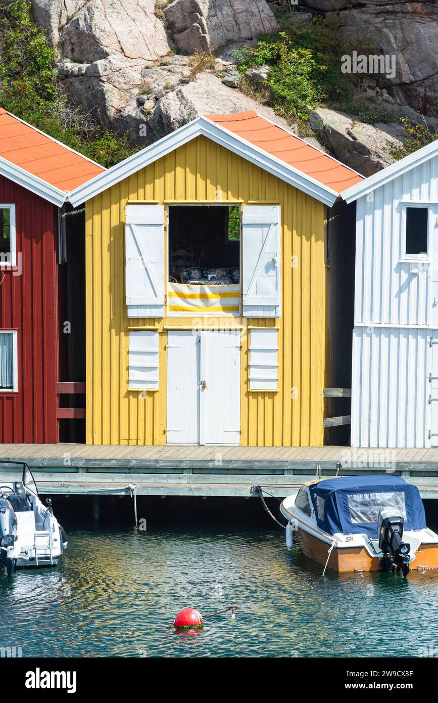 Magazzino con facciata in legno giallo davanti a rocce di granito sul lungomare del porto di Smögen, nell'arcipelago della costa occidentale svedese Foto Stock
