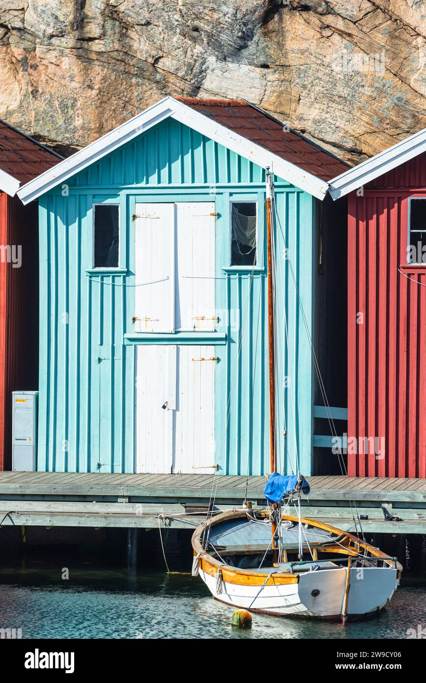 Magazzino con facciata in legno turchese di fronte a rocce di granito sul lungomare del porto di Smögen, nell'arcipelago della costa occidentale svedese Foto Stock