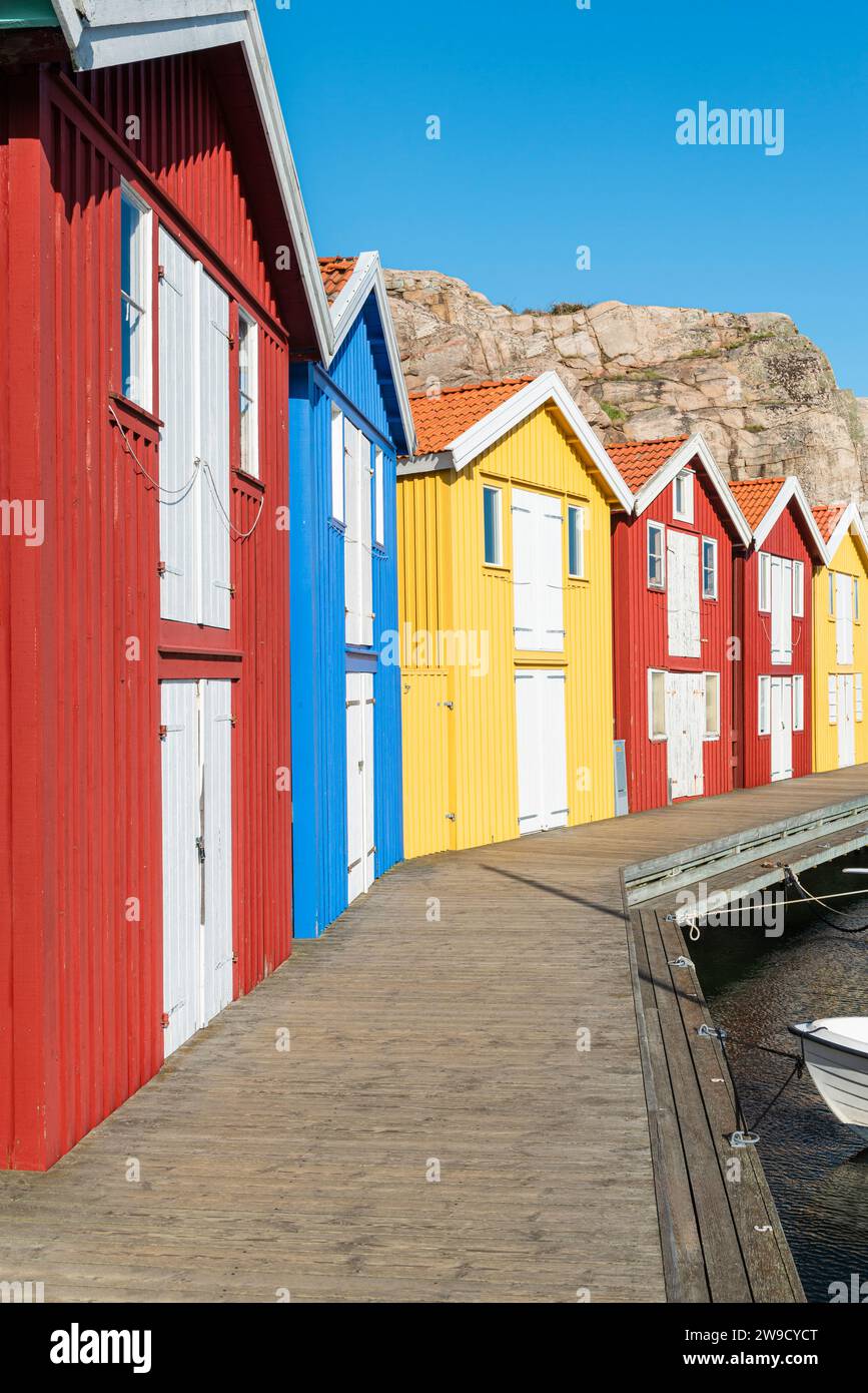 Capannoni per barche e magazzini con facciate in legno rosso tra rocce di granito nel porto di Smögen, nell'arcipelago della costa occidentale svedese Foto Stock