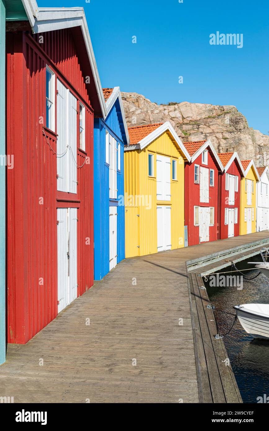 Capannoni per barche e magazzini con facciate in legno rosso tra rocce di granito nel porto di Smögen, nell'arcipelago della costa occidentale svedese Foto Stock