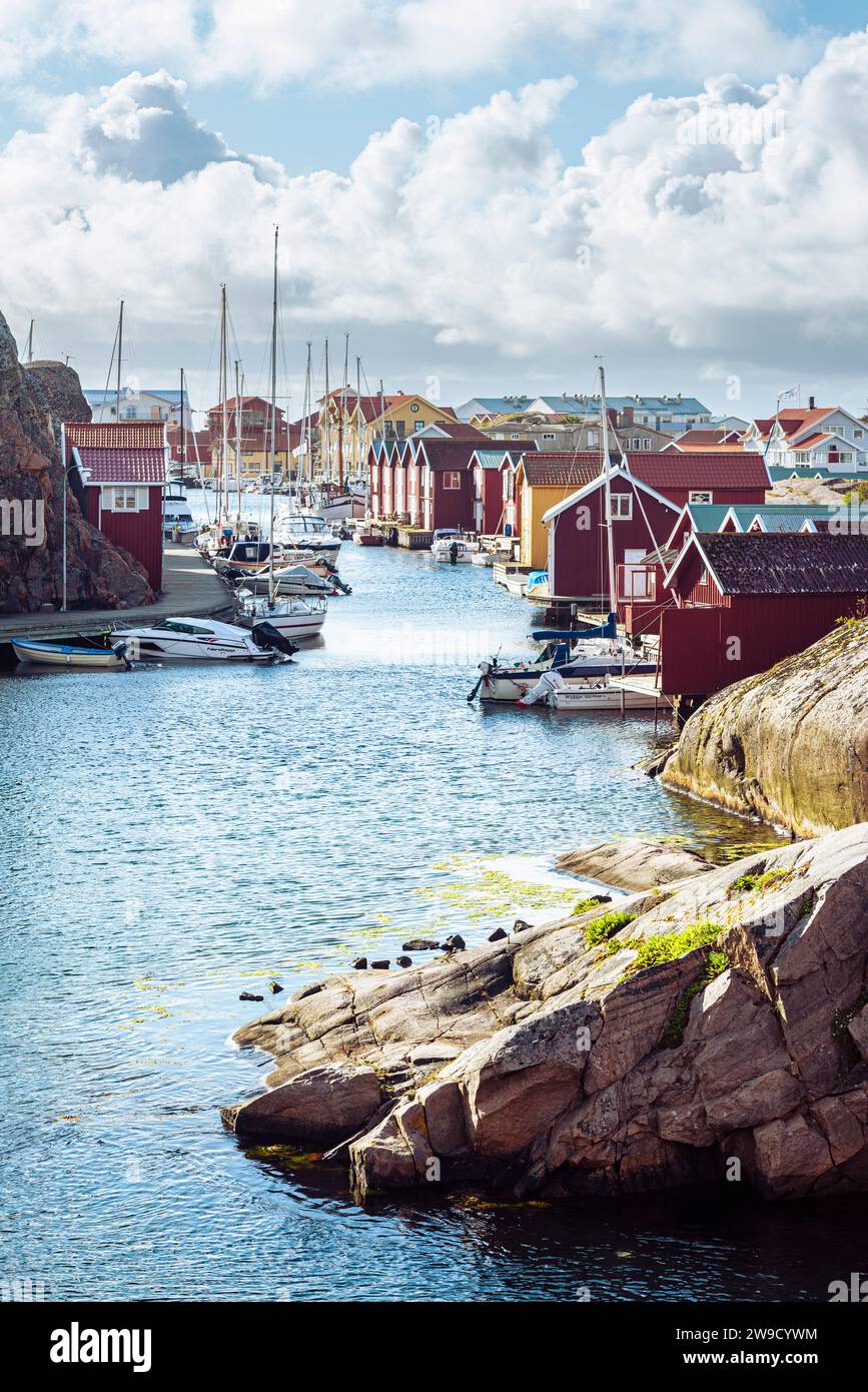 Capannoni per barche e magazzini con facciate in legno rosso e rocce di granito nel porto di Smögen, nell'arcipelago della costa occidentale svedese Foto Stock