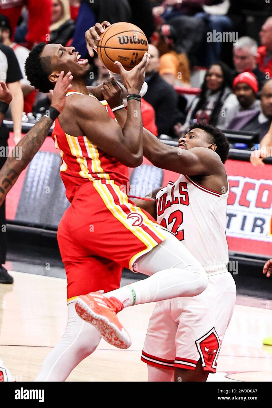 Chicago, Stati Uniti. 26 dicembre 2023. Onyeka Okongwu (L) degli Atlanta Hawks sale fino al basket durante la partita della stagione regolare NBA tra gli Atlanta Hawks e i Chicago Bulls a Chicago, negli Stati Uniti, il 26 dicembre 2023. Crediti: Joel Lerner/Xinhua/Alamy Live News Foto Stock