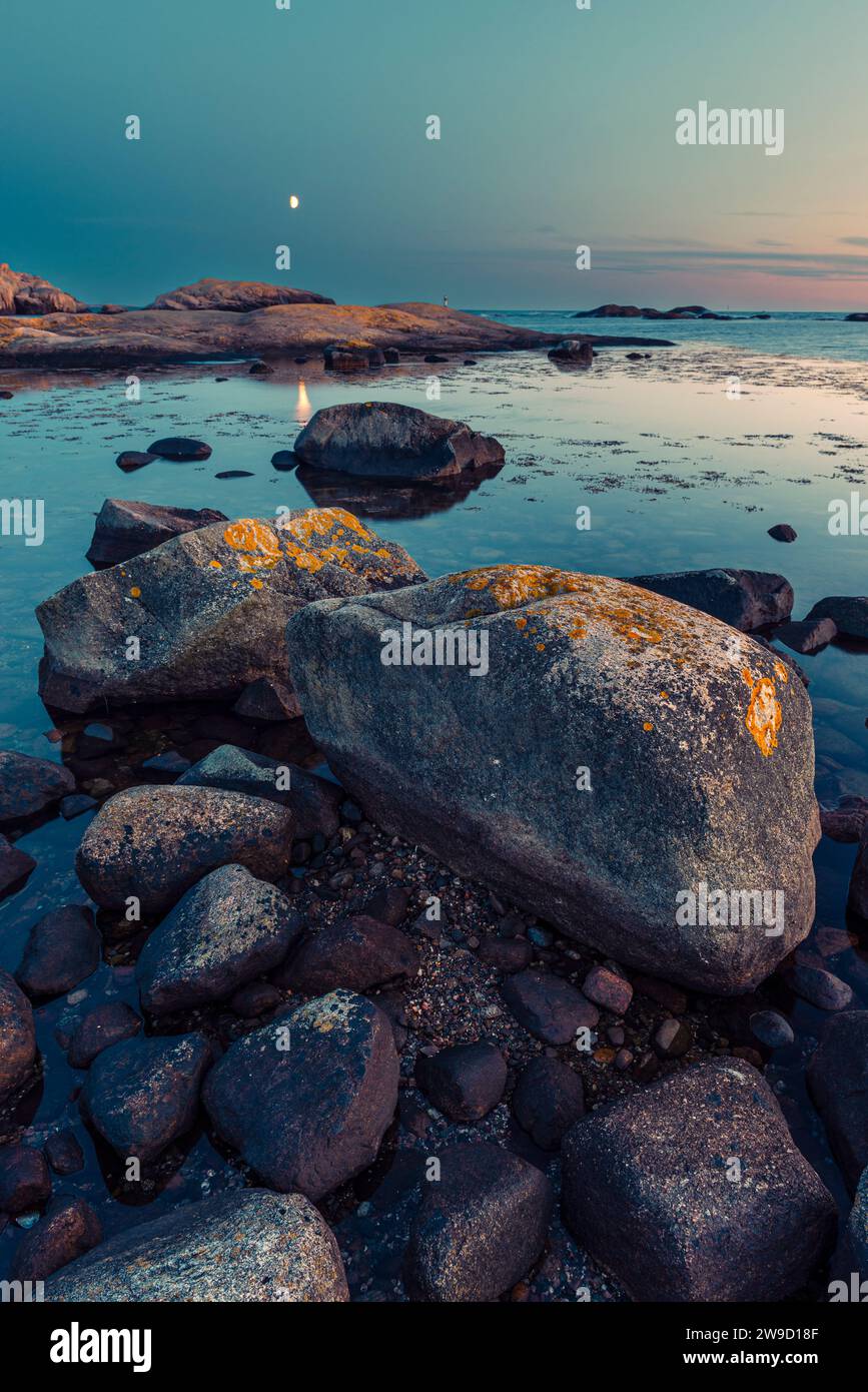 Luna nel tramonto splendente sulle rocce nella riserva naturale Tjurpannan nell'arcipelago della costa occidentale svedese Foto Stock