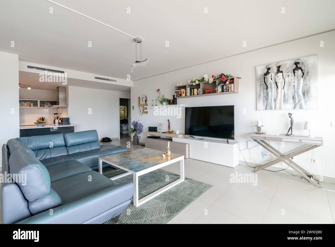 un'immagine di un lussuoso soggiorno completo di cucina a vista in un appartamento mediterraneo Foto Stock