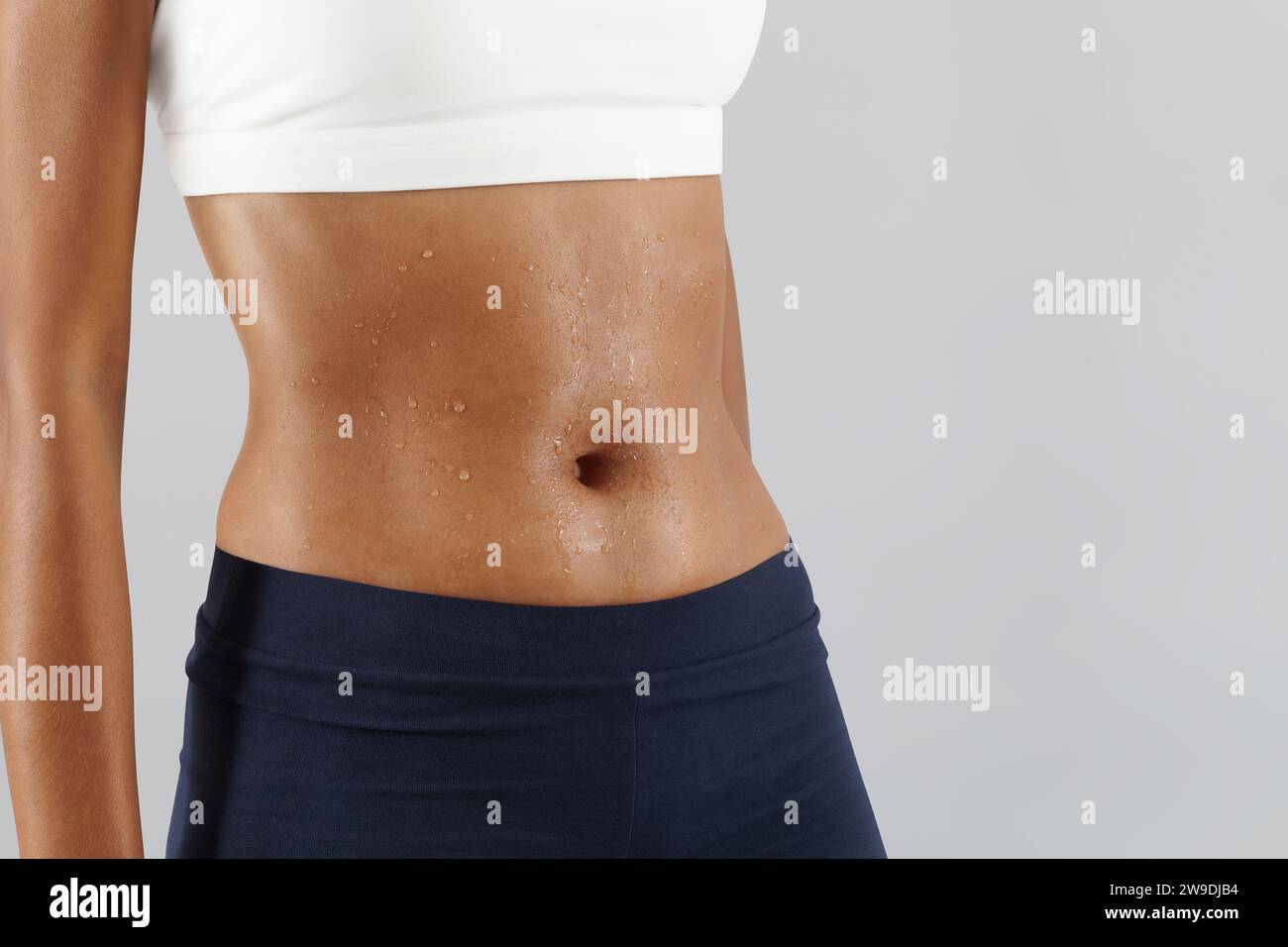 Allenamento fitness, donna sudore addome, gocce di sudore sulla pancia della pelle da vicino, atleta afro-americana femminile in abbigliamento sportivo, Sportswoman do exer Foto Stock