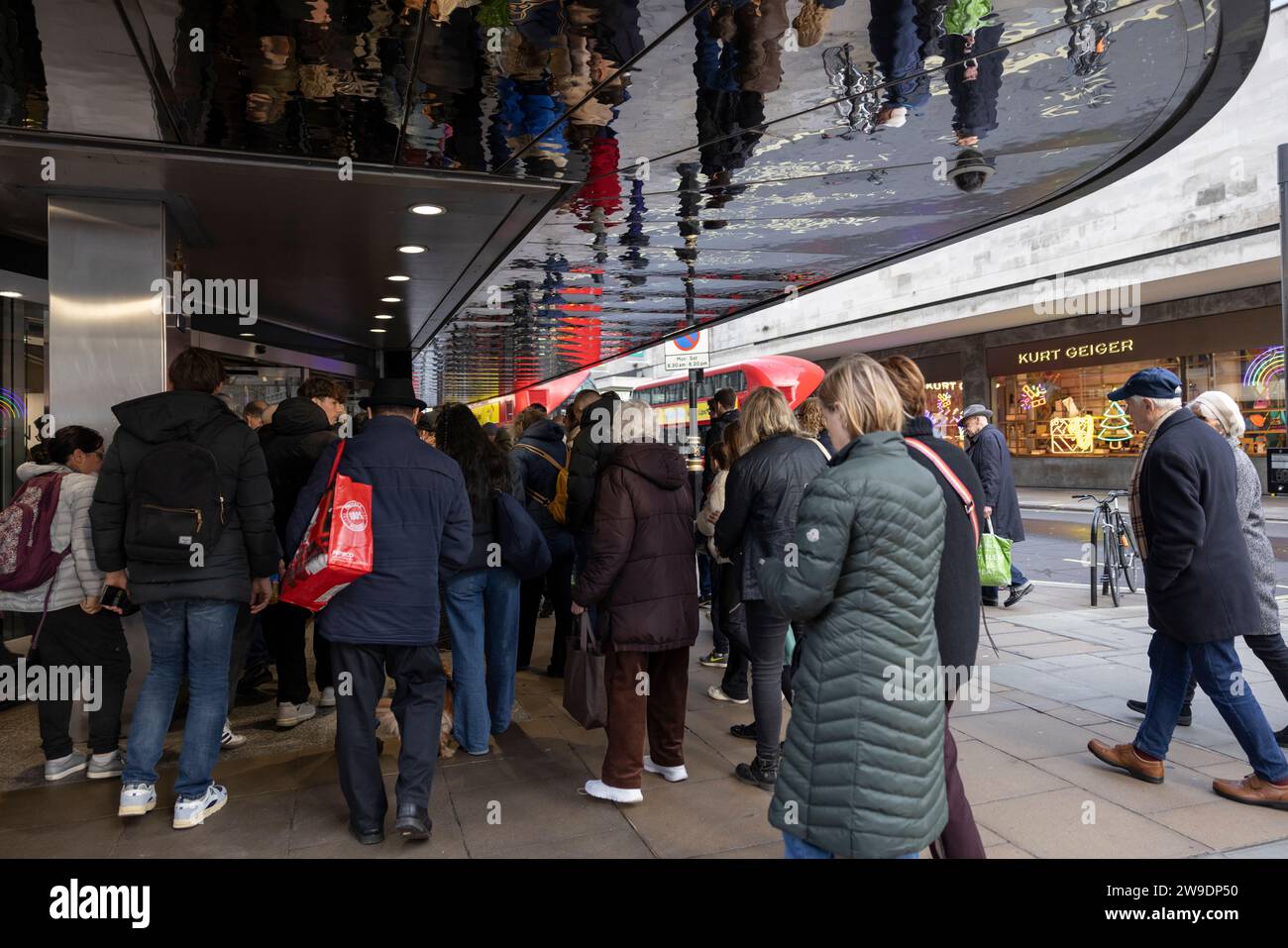 Gli amanti dello shopping natalizio fanno la fila all'esterno dei grandi magazzini John Lewis lungo Oxford Street nell'ultimo giorno di shopping della stagione festiva prima di Natale, Regno Unito Foto Stock