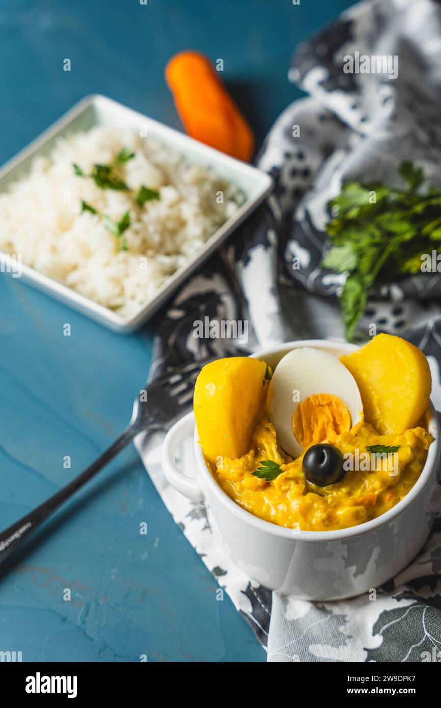 Piatto tradizionale chiamato aji de gallina con una porzione di riso, molto popolare nella gastronomia peruviana. Foto Stock