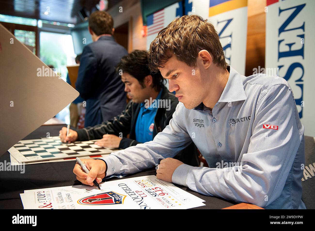 8 SETTEMBRE 2013 -- ST. LOUIS -- il grande maestro di scacchi norvegese Magnus Carlsen (a destra) e il grande maestro di scacchi americano Hikaru Nakamura segno da giocare a tavole e. Foto Stock