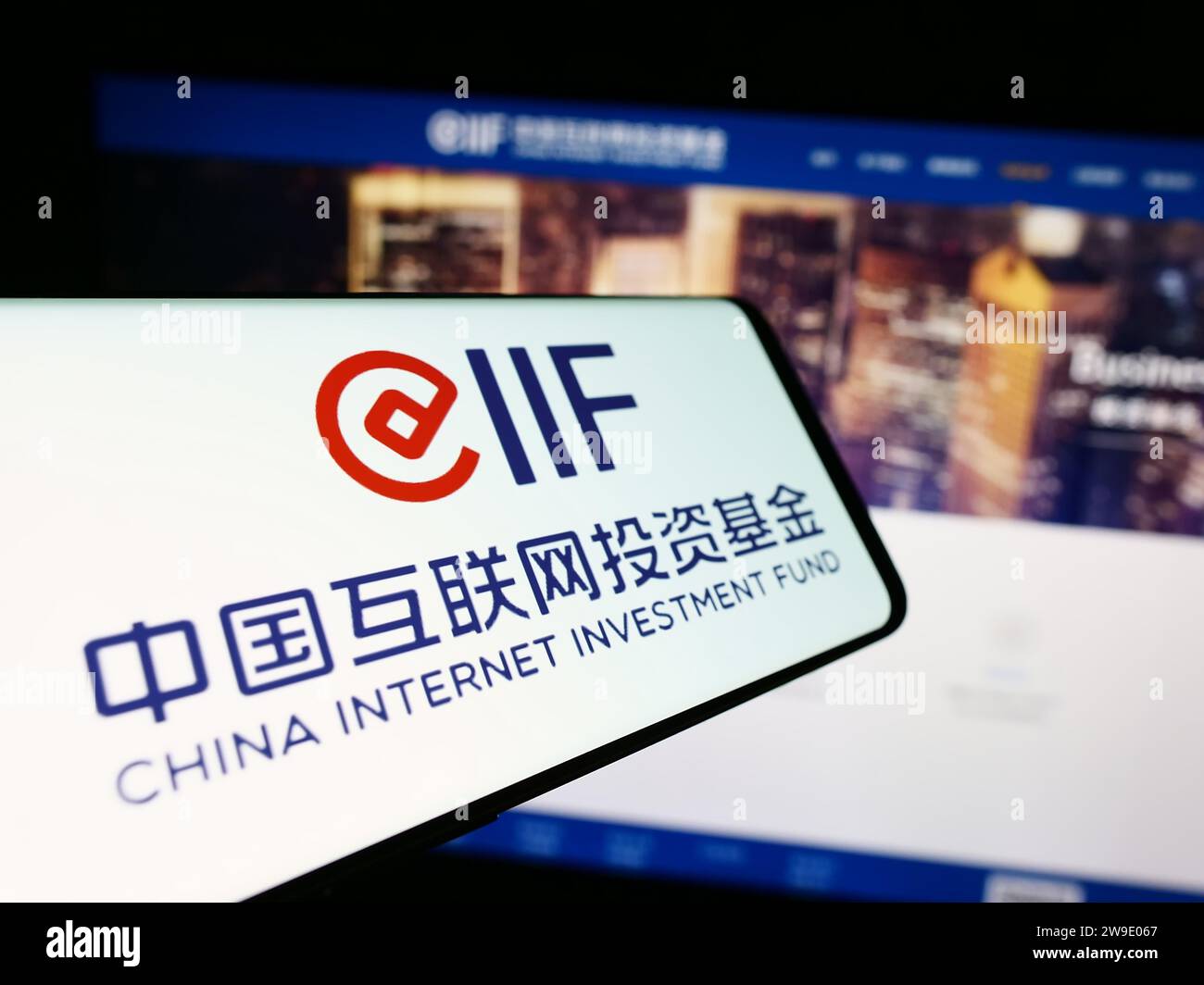 Smartphone con il logo del China Internet Investment Fund (CIIF) davanti al sito Web aziendale. Mettere a fuoco il display centrale sinistro del telefono. Foto Stock