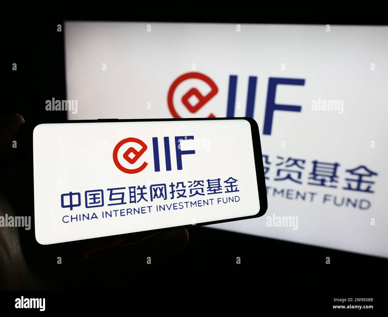 Persona che possiede un telefono cellulare con il logo del China Internet Investment Fund (CIIF). Concentrarsi sul display del telefono. Foto Stock