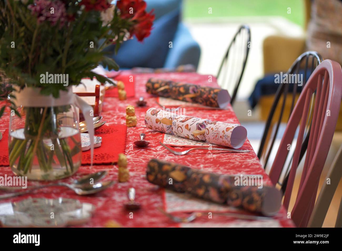 Impostazioni del tavolo di Natale, con cracker, decorazioni festive, ambientazioni, pronto per la cena, mangiare la cena di Natale Foto Stock