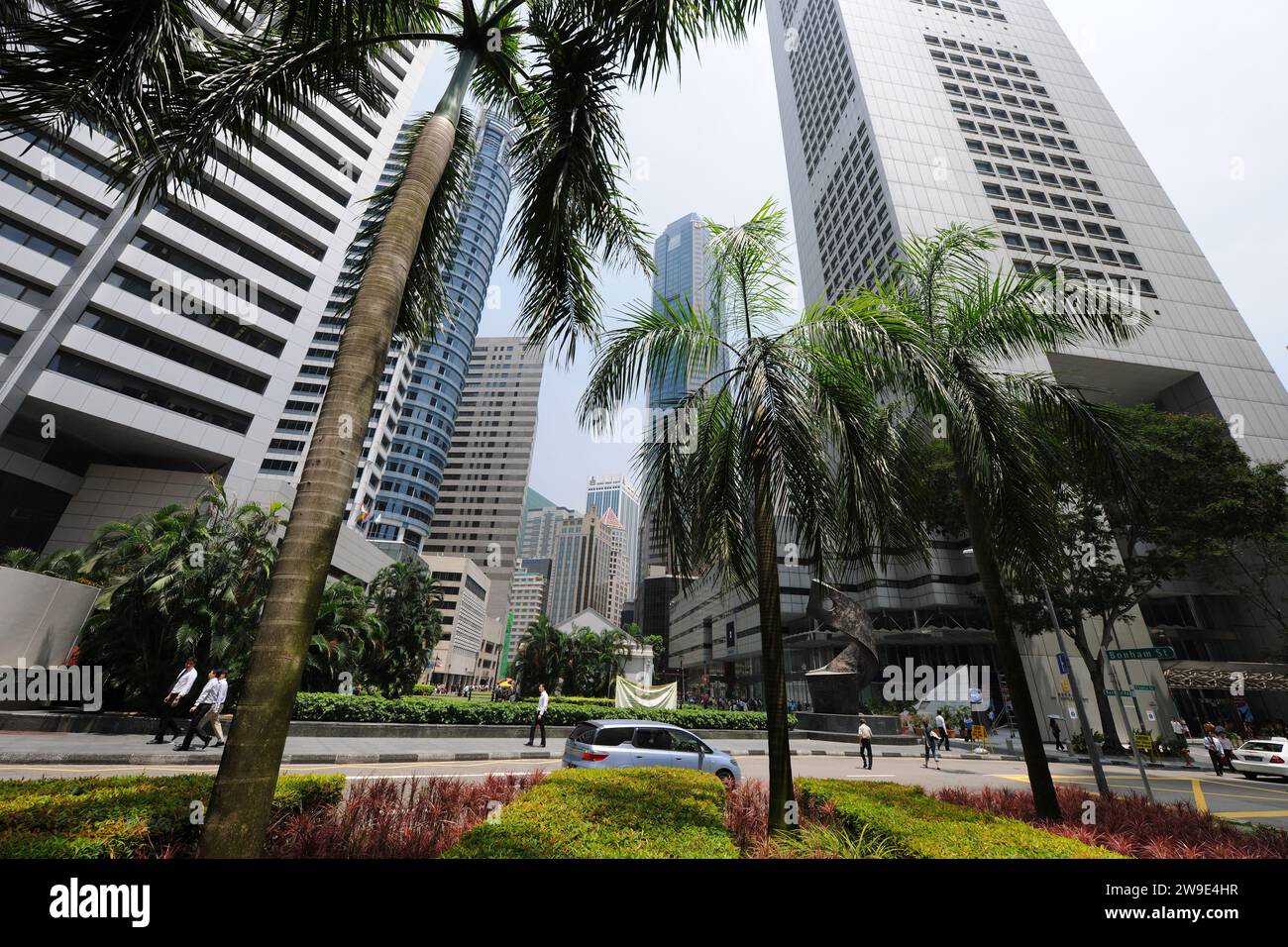 Scena stradale di Singapore con palme e grattacieli sulla Battery Road che guarda al Raffles Place Foto Stock