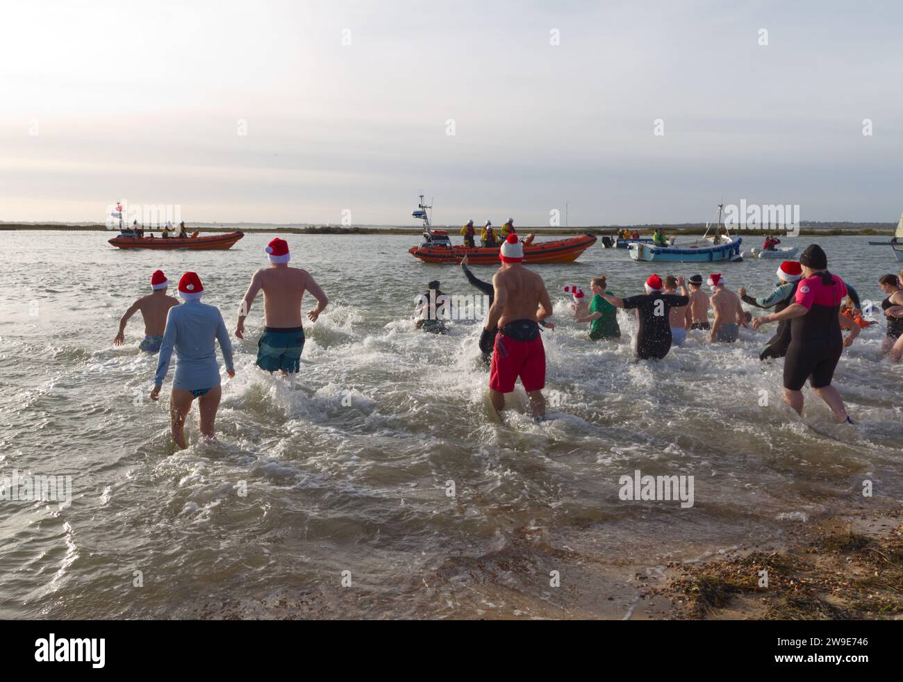 RNLI Boxing Day DIP nel 2023. La gente affronta il freddo e il mare per raccogliere fondi per le scialuppe di salvataggio del Mersea occidentale. Foto Stock