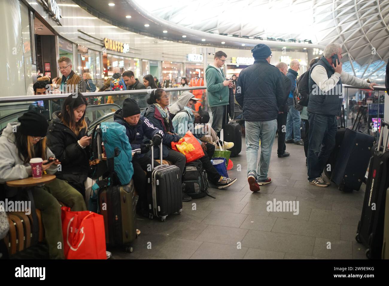 Passeggeri alla stazione King's Cross di Londra. I problemi relativi a due progetti di ingegneria ferroviaria di Natale stanno causando gravi disagi mercoledì. I servizi all'estremità meridionale della Midland Main Line tra St Albans e London St Pancras sono influenzati da un guasto al sistema di segnalazione, mentre il superamento dei lavori di ingegneria ha causato la miseria per molti passeggeri del sud-est. La East Midlands Railway ha affermato che la questione del segnalamento le impedisce di effettuare servizi tra Londra St Pancras e l'aeroporto di Luton, il che significa che migliaia di passeggeri rischiano di perdere i voli. Data foto: Mercoledì 27 dicembre, Foto Stock