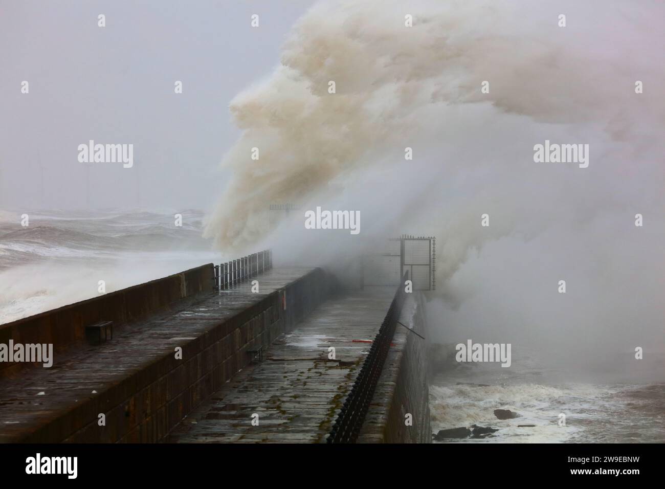 Enormi onde che si infrangono su un molo di pietra durante una tempesta a Hartlepool Headland, contea di Durham, Inghilterra, Regno Unito. Foto Stock