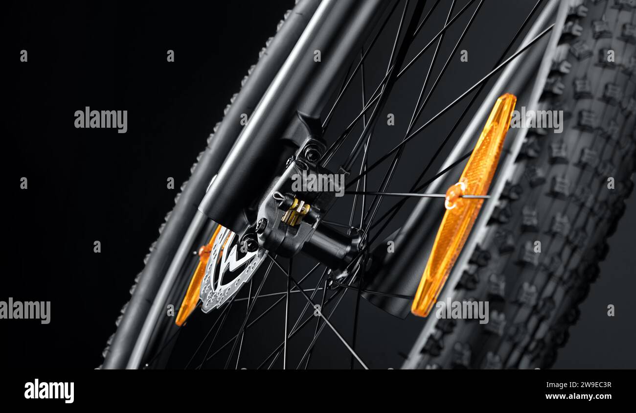 Primo piano della ruota anteriore di una nuova mountain bike su sfondo nero. Foto studio. Attrezzature sportive professionali. Foto Stock