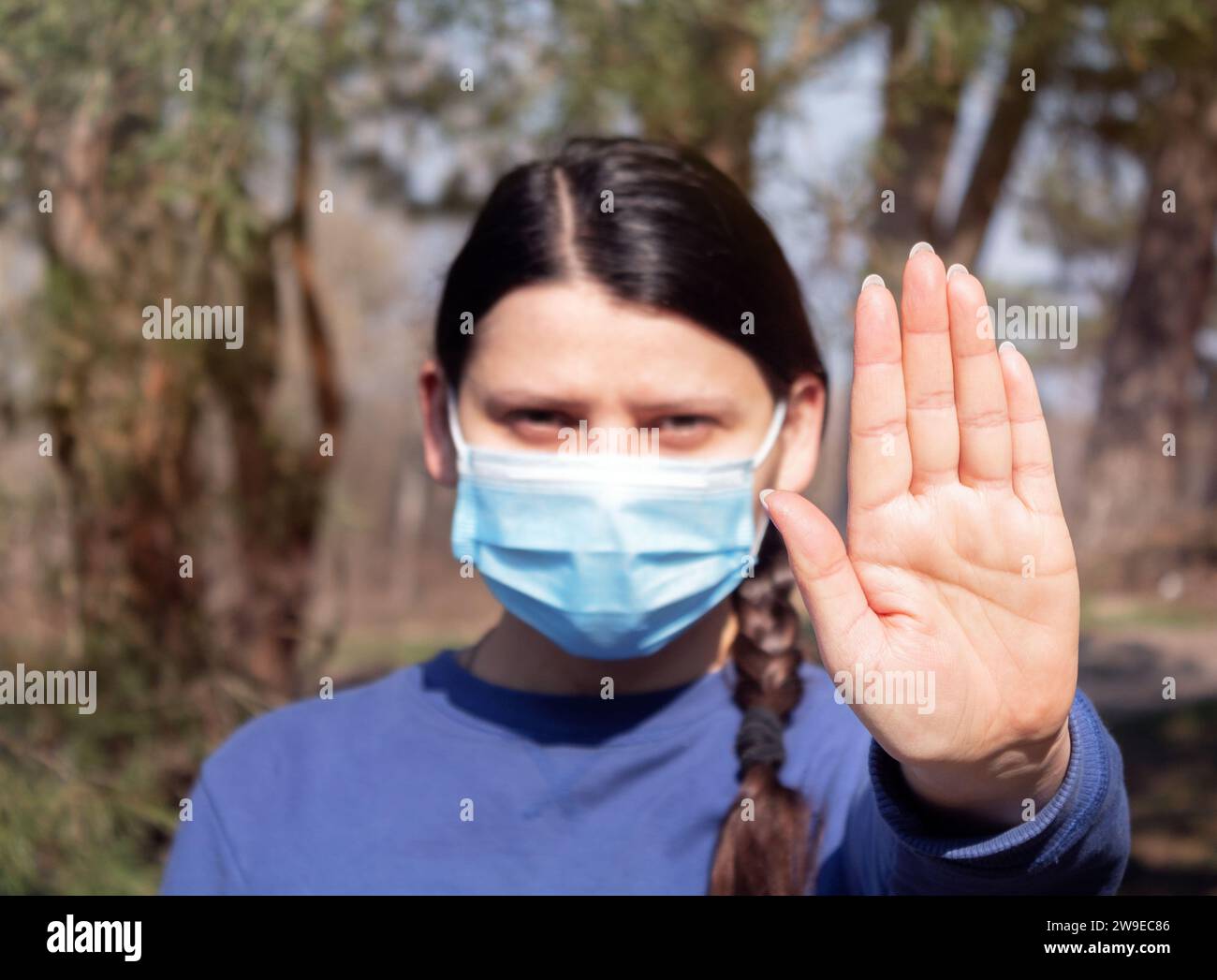 Ragazza in maschera medica mostra un palmo. Fermare il concetto di malattia virale. Pericolosa epidemia mortale di nCoV Foto Stock