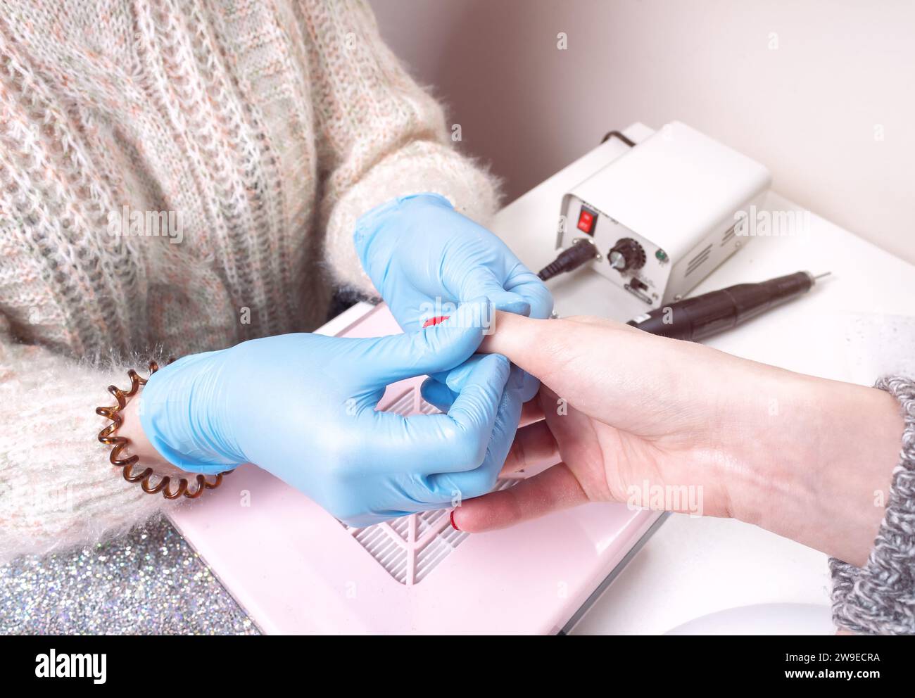 Il manicurista strofina l'olio cuticolo in un dito. Processo di manicure in un salone di bellezza. Foto Stock
