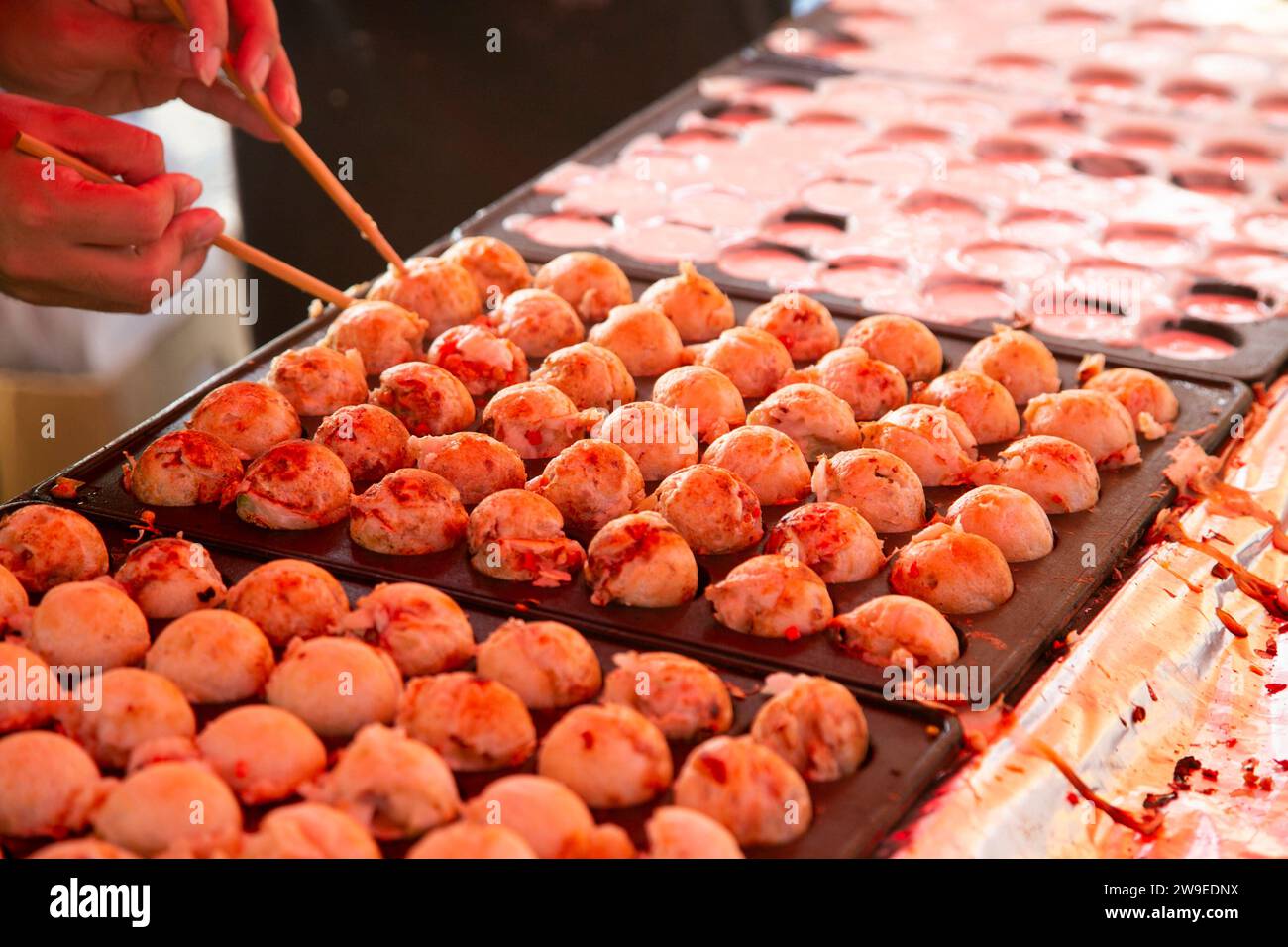 Il Takoyaki è un alimento giapponese a base di farina di grano e polpo. E' fatto a forma di palla. Foto Stock