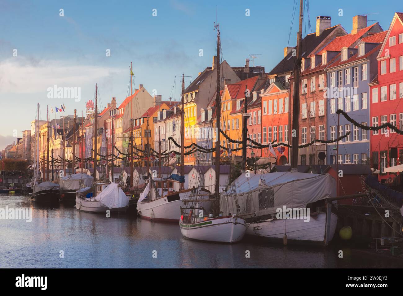 Copenaghen, Danimarca - 18 novembre 2017: Luce del sole dorata sul colorato lungomare del canale di Nyhavn (porto nuovo), una popolare attrazione turistica di Co Foto Stock