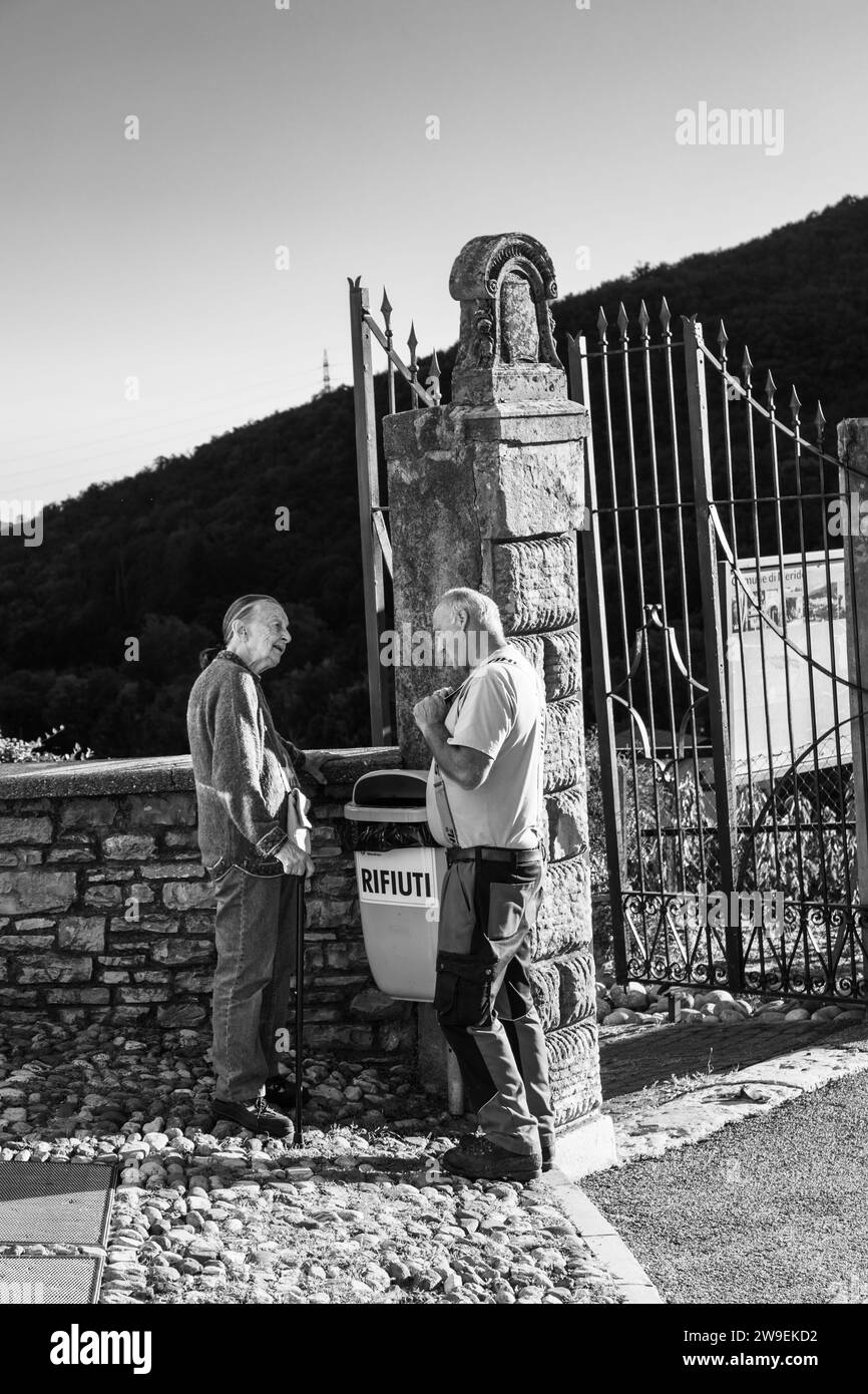 Uomo e donna che parlano per strada, Meride, Ticino, Svizzera Foto Stock