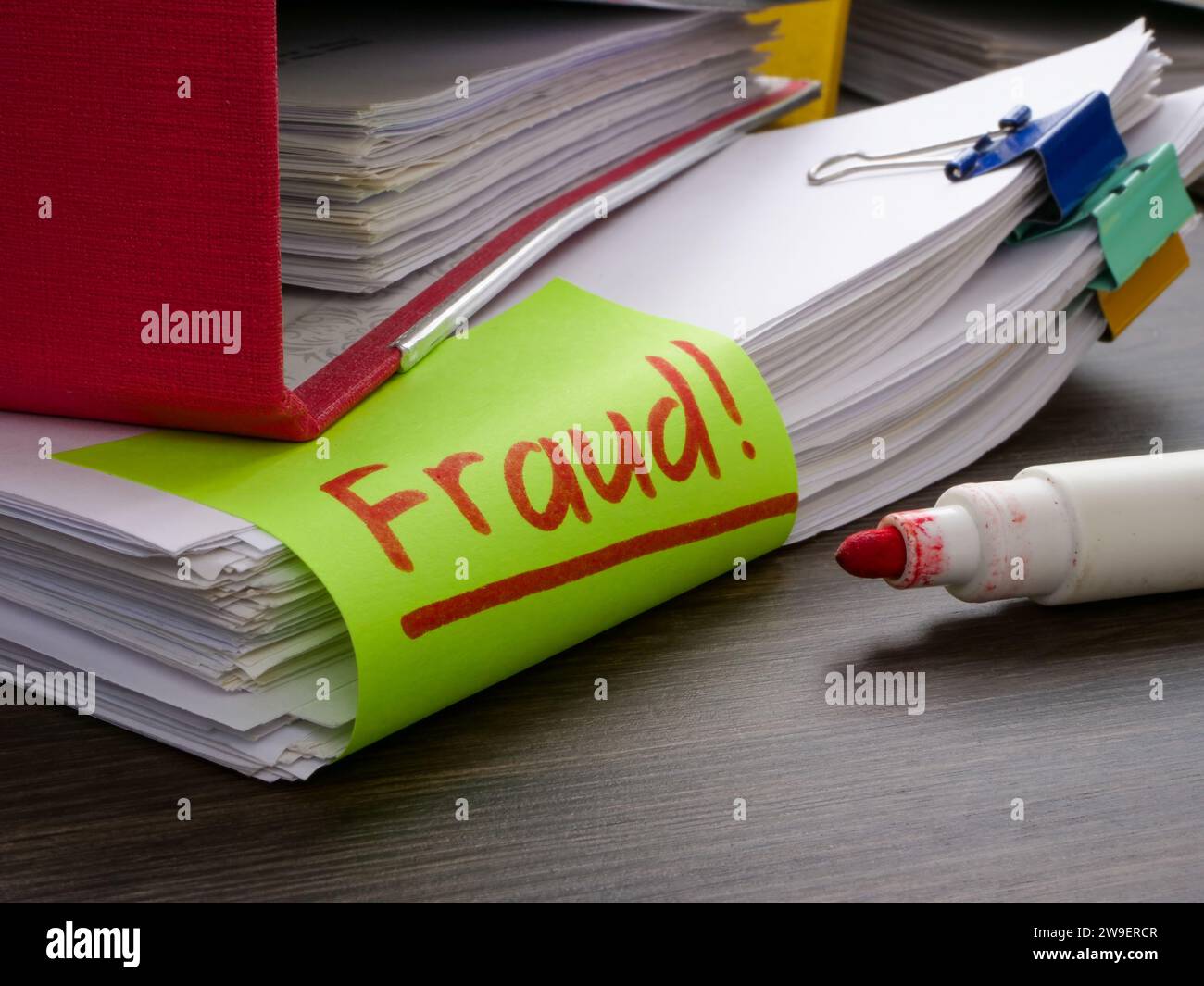 Una cartella e una pila di documenti su finanze o tasse con una frode di iscrizione. Foto Stock