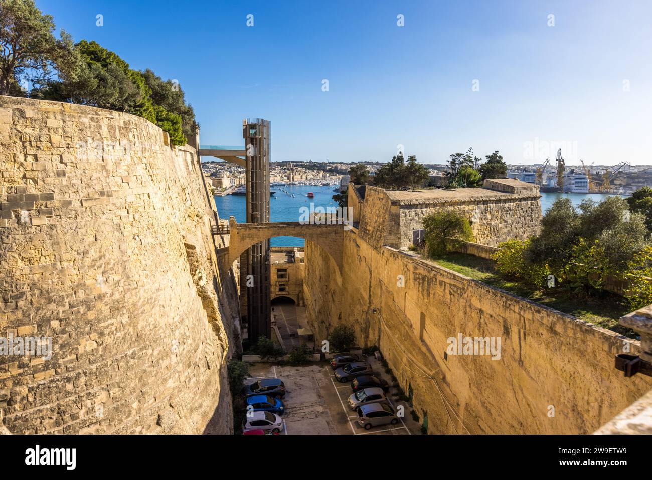 L'ascensore in vetro del Barrakka Lift scende attraverso le mura bastionate di Valletta fino al porto, Malta; le auto ora parcheggiano nel precedente fossato cittadino sottostante. Aperto nel 2012, l'ascensore alto 58 metri ha sostituito un precedente ascensore costruito nel 1905, che è stato dismesso nel 1973 e demolito nel 1983. ## Batch Malta 05 (2026-09-07) Foto Stock