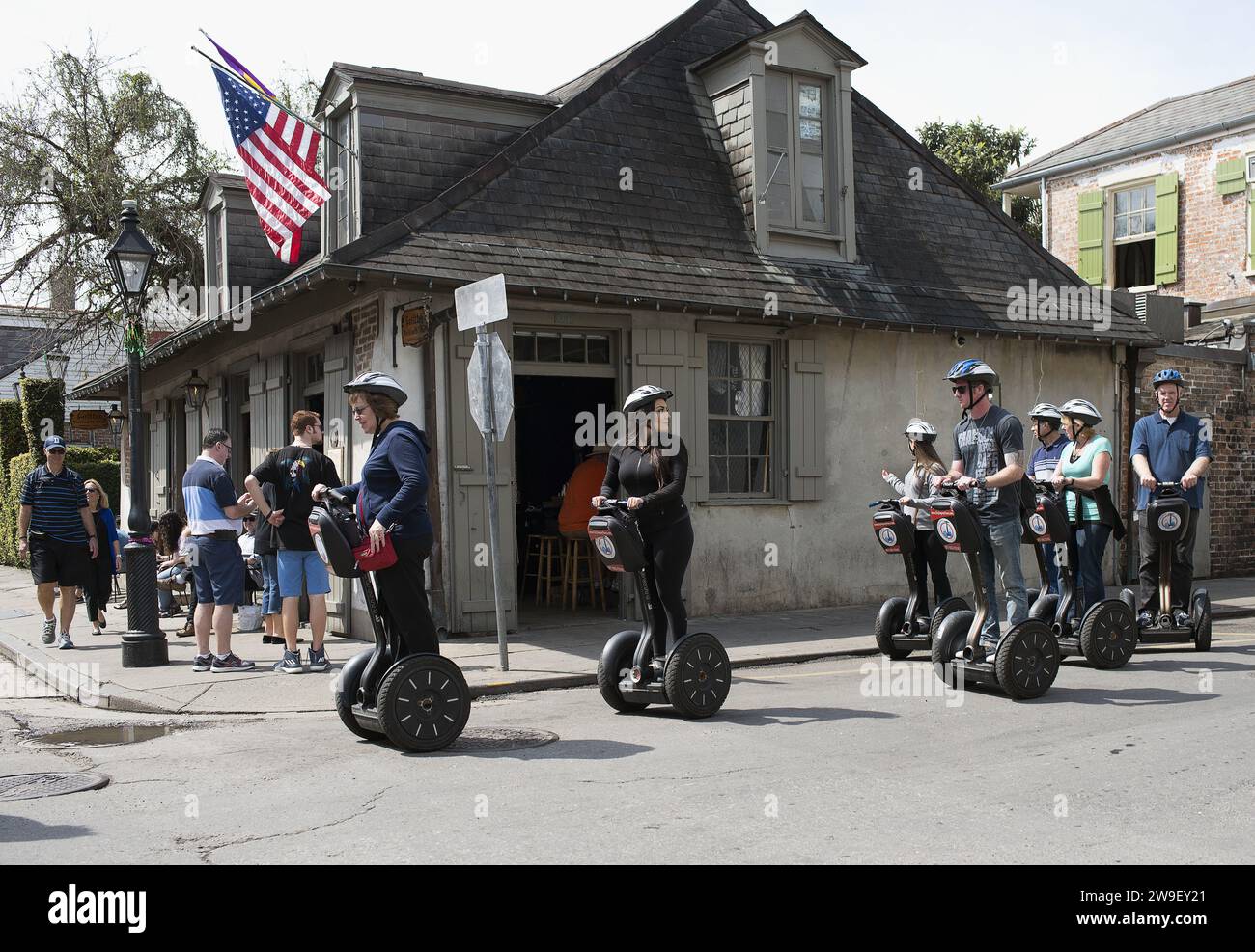 I turisti che viaggiano in Segway attraverso il quartiere francese di New Orleans con Lafittes all'angolo tra Bourbon e St Philips sullo sfondo. Foto Stock