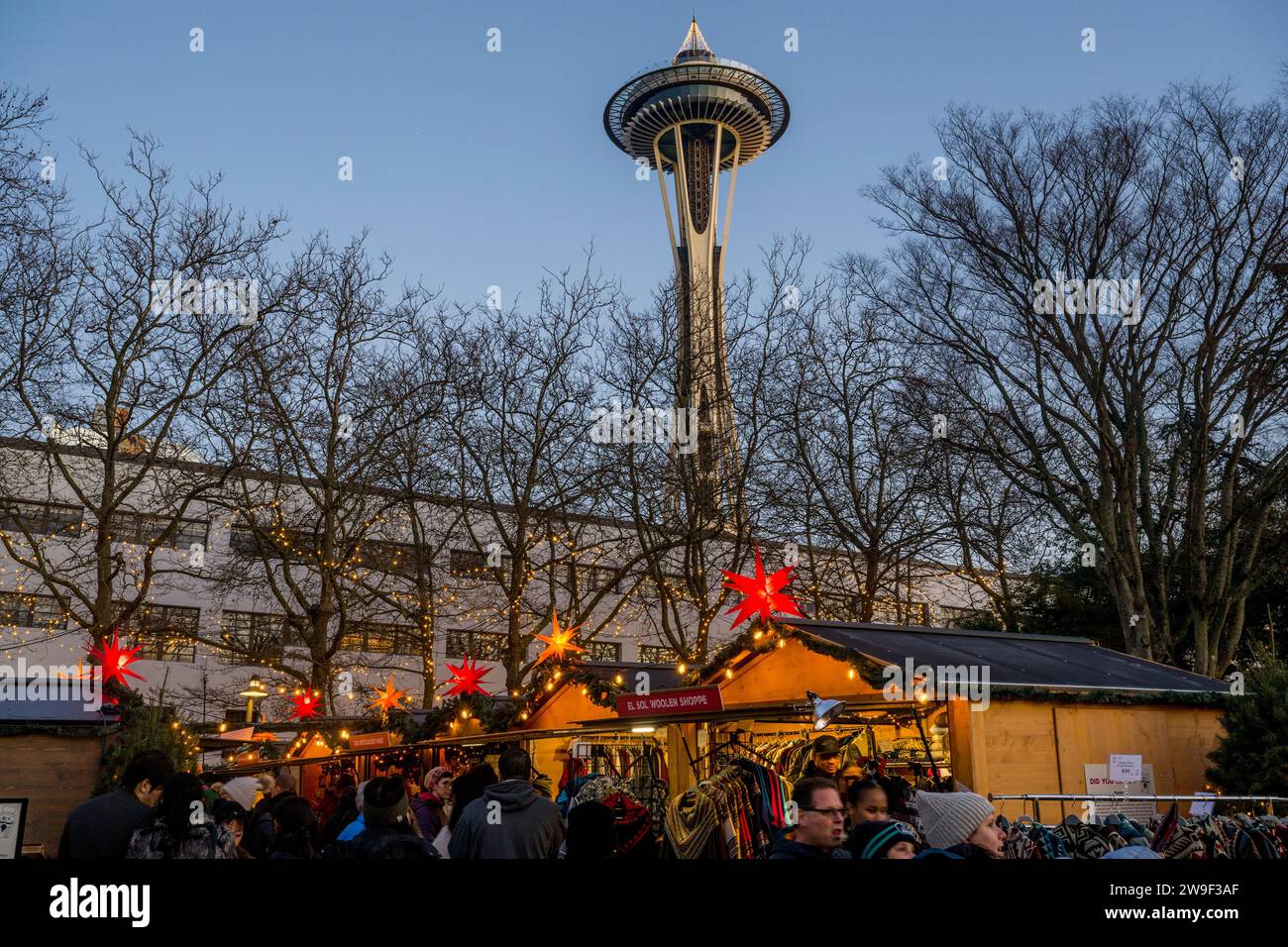 Il mercato di Natale di Seattle con capanne, luci per le feste, gente e lo Space Needle al Seattle Center di Seattle, Stato di Washington, Stati Uniti. Foto Stock