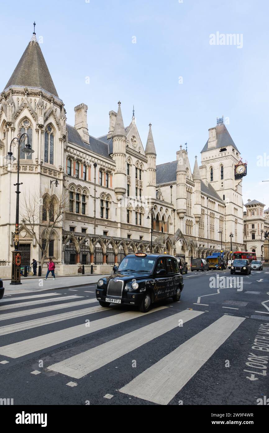 Londra, Regno Unito - 16 marzo 2023; taxi nero di Londra che passa accanto all'edificio Royal Courts of Justice Foto Stock