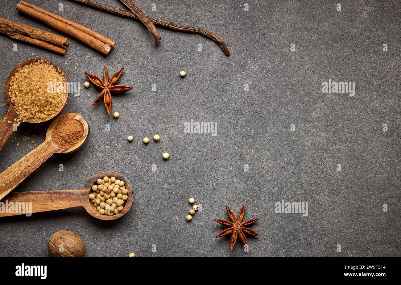 varie spezie per la cottura su sfondo grigio scuro, vista dall'alto Foto Stock