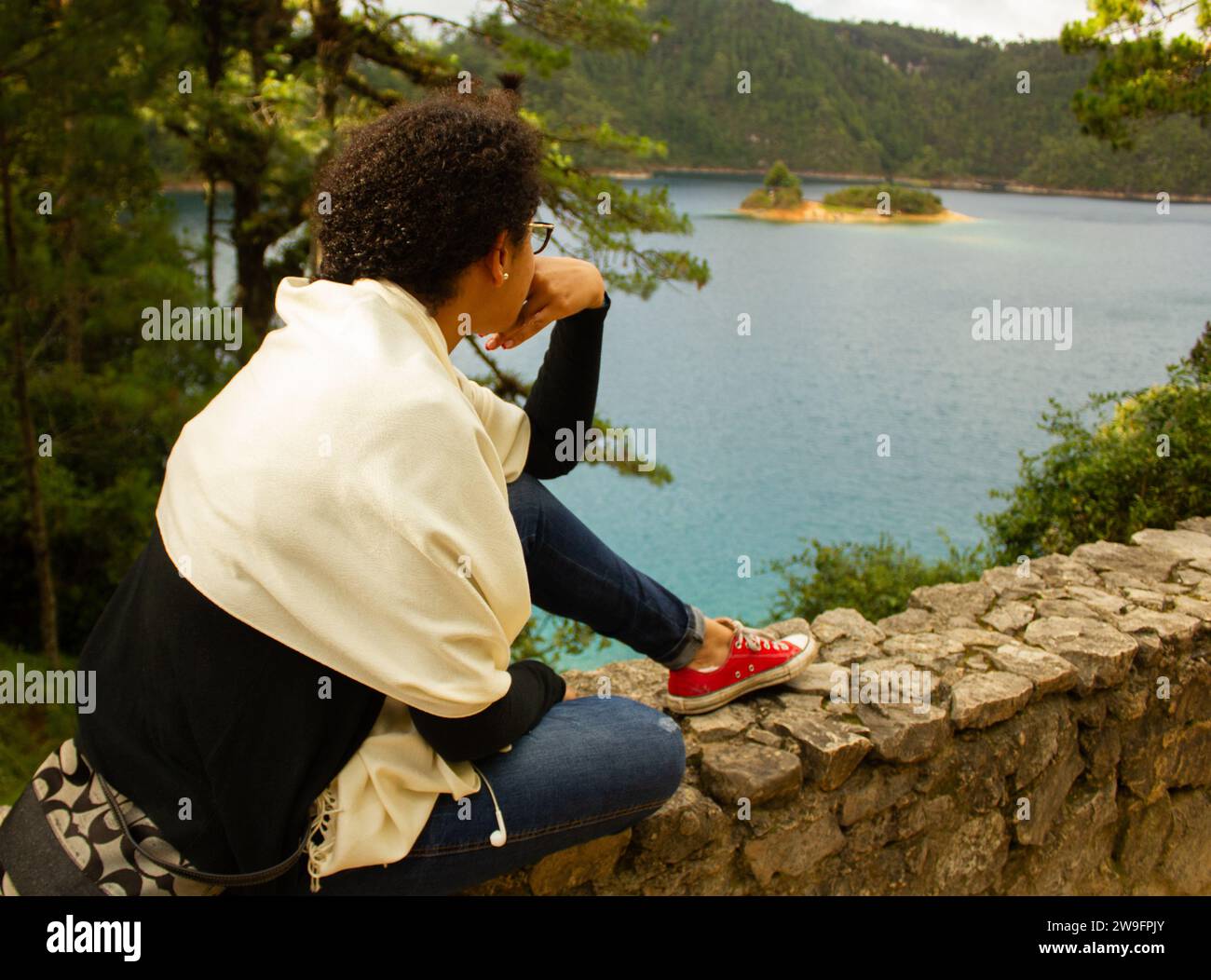 Lakeside Serenity: Donna che contempla i laghi del sud-est del Messico, le acque blu, il clima freddo, avvolti nella foresta Foto Stock