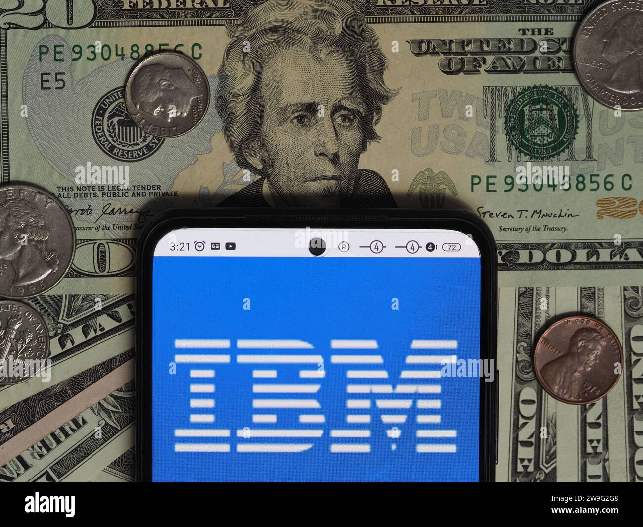 Baviera, Germania - 28 dicembre 2023: In questa foto, un logo IBM visibile su uno smartphone con banconote e monete in dollari statunitensi Foto Stock