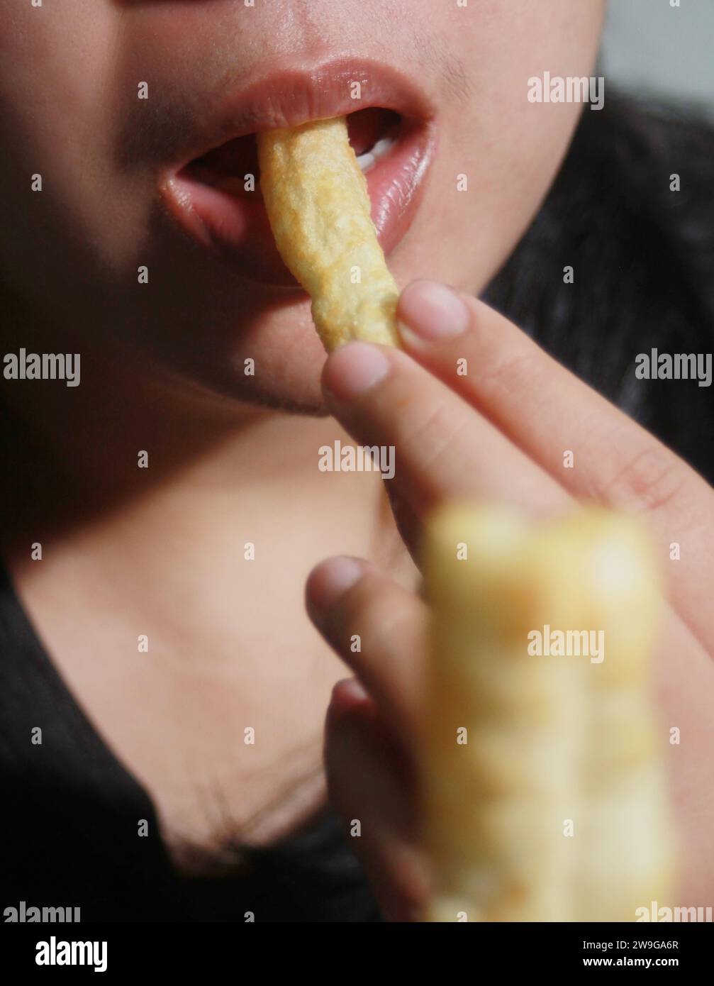 Donna che mangia pasticcini croccanti, è un popolare cibo di strada che è delizioso e si trova comunemente in paesi asiatici come Thailandia, Cina, Laos, Vietn Foto Stock