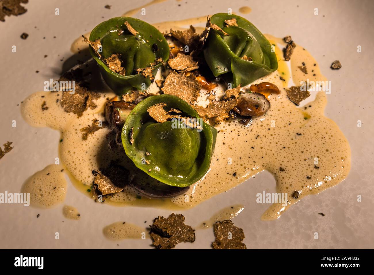 Tre capsule di pasta verde ricoperte di tartufo nero grattugiato riposano in una salsa di panna schiumosa al ristorante stellato Michelin Noni a Valletta, Malta. Lo chef Jonathan Brincat gestisce il ristorante in Republic Street sin dalla sua apertura nel 2017; nel 2020 è diventato uno dei primi tre ristoranti di Malta a ottenere una stella Michelin. Foto Stock