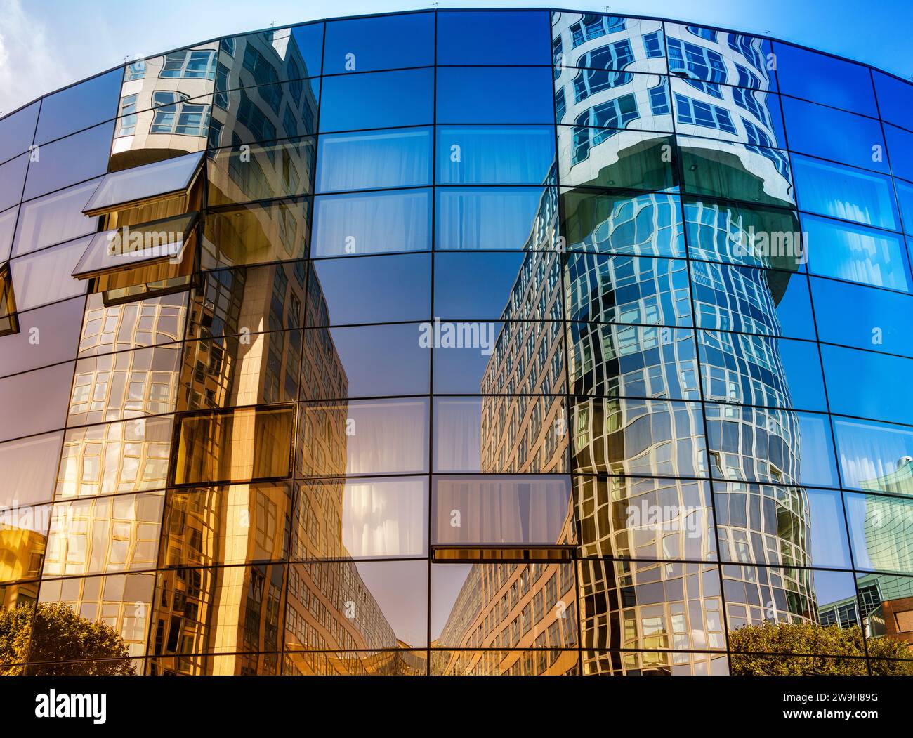 Le torri degli uffici si riflettono nella facciata in vetro dell'Abion Hotel, Spreebogen Alt-Moabit, Berlino, Germania Foto Stock