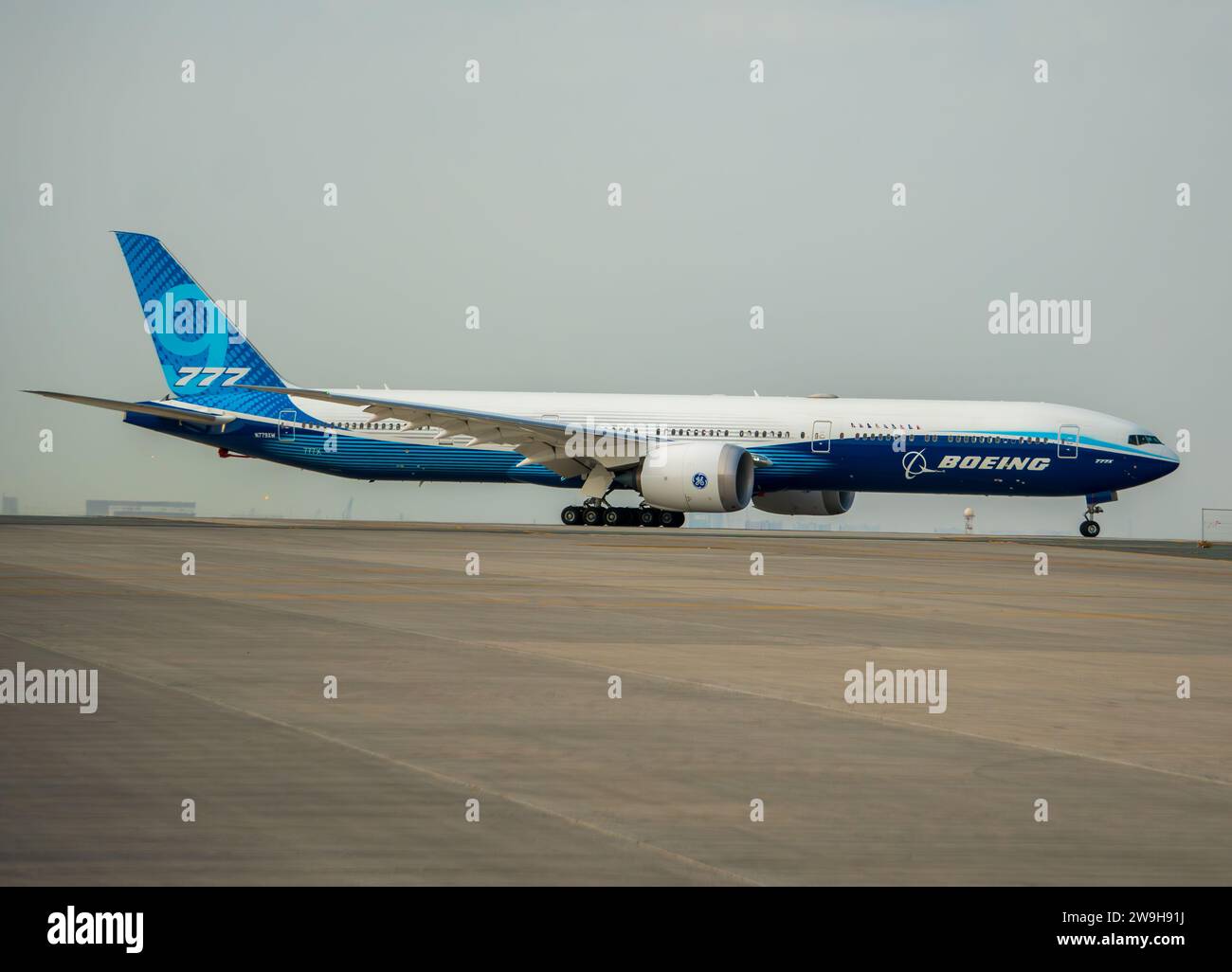 Un boeing 777 con livrea Boeing che si prepara al decollo per un volo dimostrativo sull'asfalto dell'aeroporto di Dubai al Maktoum. Cielo grigio nebbioso. Foto Stock