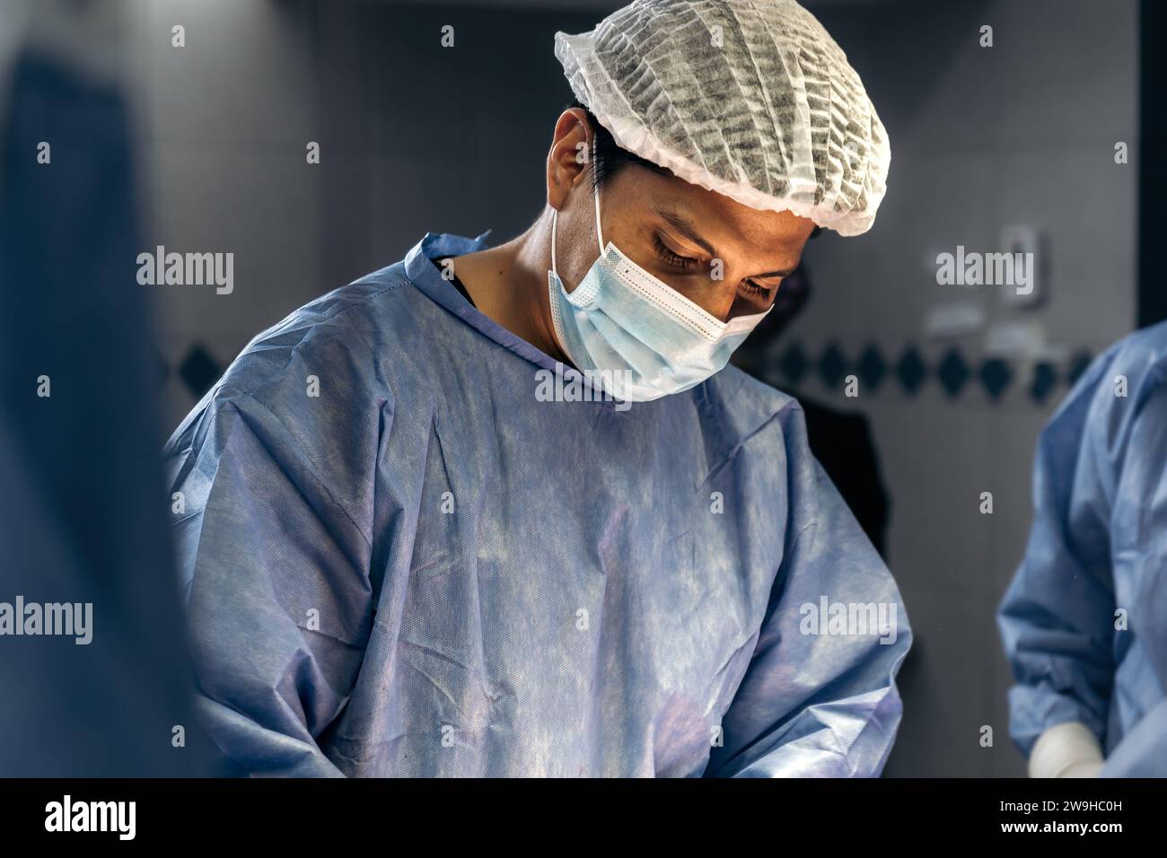 Un chirurgo maschile esperto che esegue un meticoloso intervento di scoliosi in una struttura medica Foto Stock