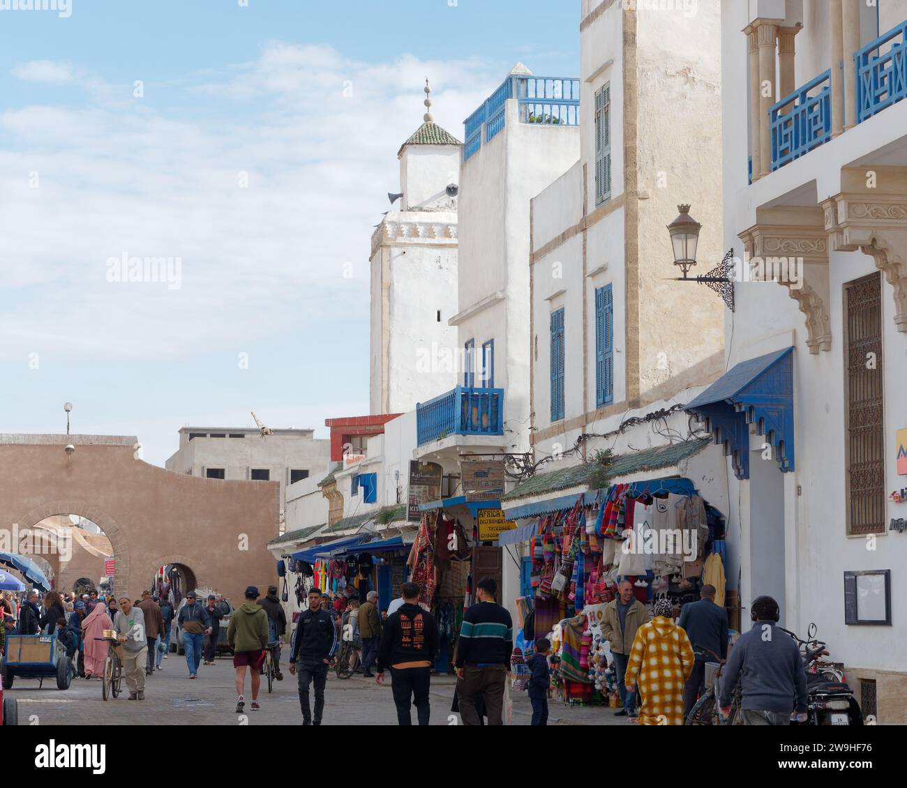 Vivace strada principale nella Medina con arco nella città di Essaouira, Marocco. 28 dicembre 2023 Foto Stock