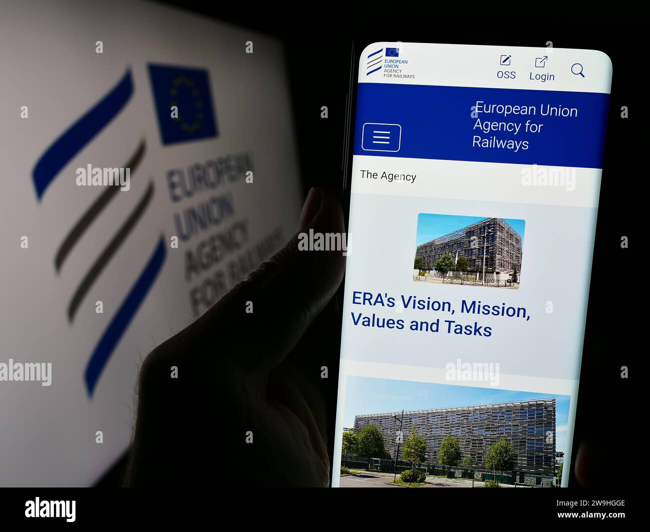 Persona in possesso di cellulare con pagina web dell'istituzione dell'UE Agenzia dell'Unione europea per le ferrovie (ERA) con logo. Concentrarsi sul centro del display del telefono. Foto Stock