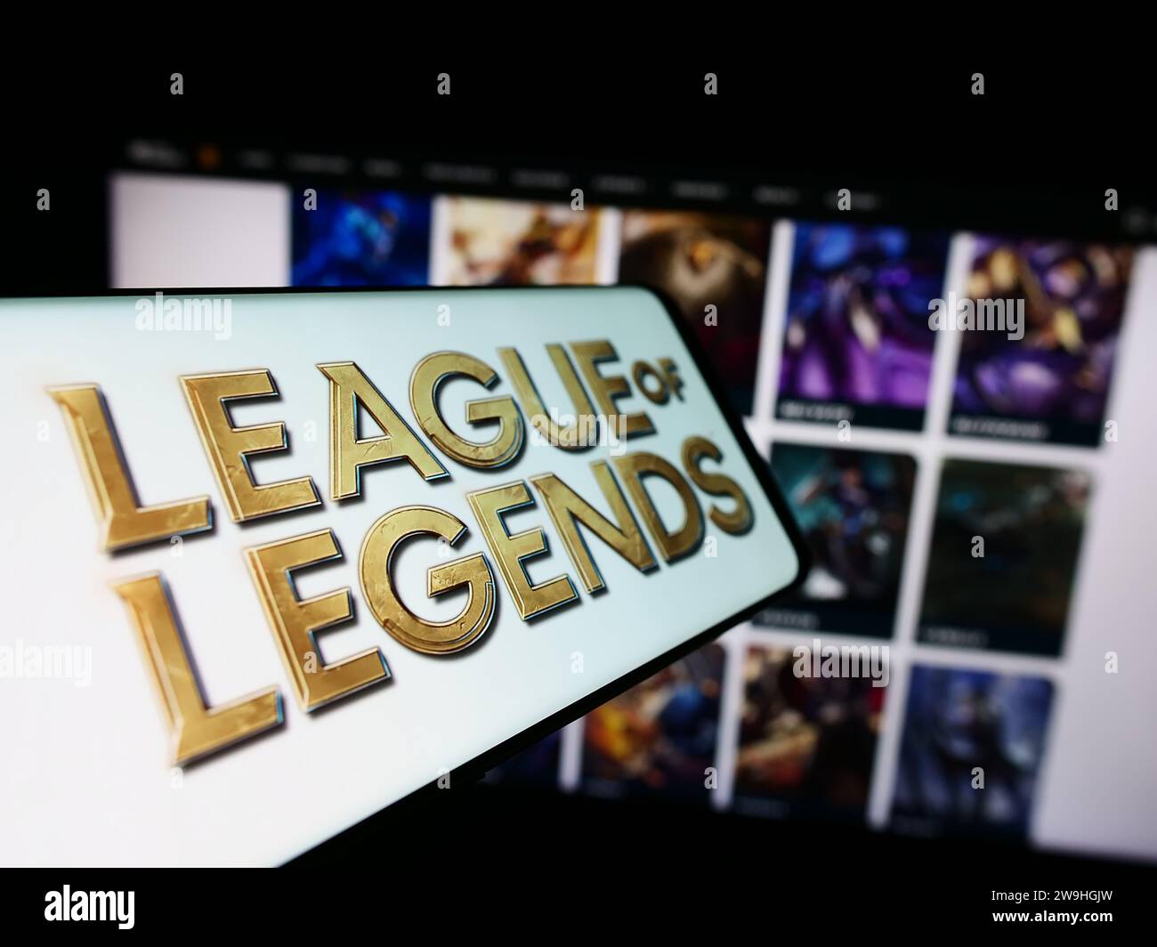 Telefono cellulare con il logo del videogioco multiplayer online League of Legends (LoL) davanti al sito Web. Mettere a fuoco il display centrale sinistro del telefono. Foto Stock