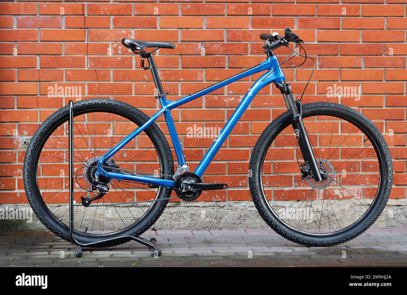 Una mountain bike blu contro un muro di mattoni. Stile di vita sano. Vendita di biciclette. Foto Stock