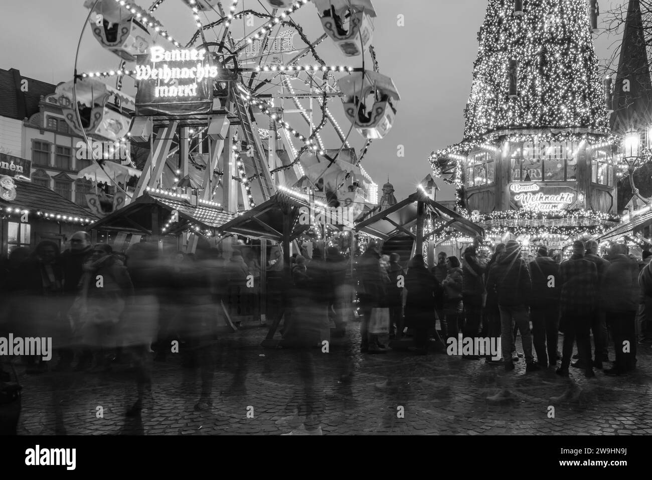 Bonn, Germania - 16 dicembre 2023: Veduta di un albero di Natale illuminato e di una ruota panoramica al mercatino di Natale di Bonn in Germania Foto Stock
