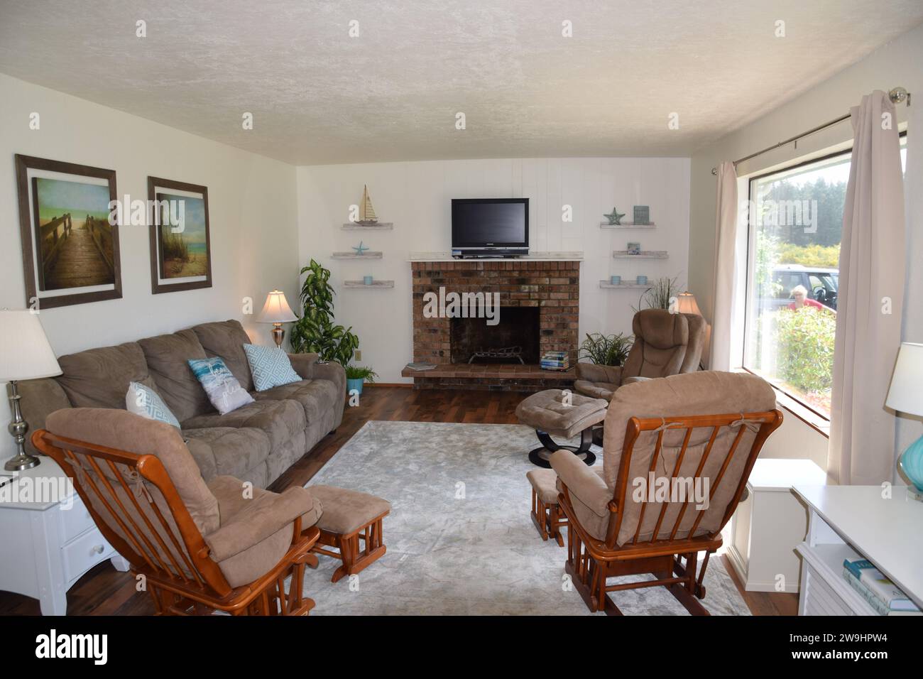 Soggiorno a tema spiaggia con caminetto e sedie a dondolo. Foto Stock