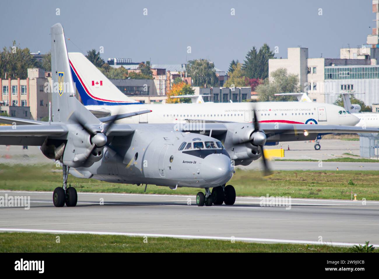 Le forze armate ucraine Antonov An-26 rallentano dopo l'atterraggio a Leopoli con la Royal Canadian Air Force Airbus CC-150 Polaris sullo sfondo Foto Stock