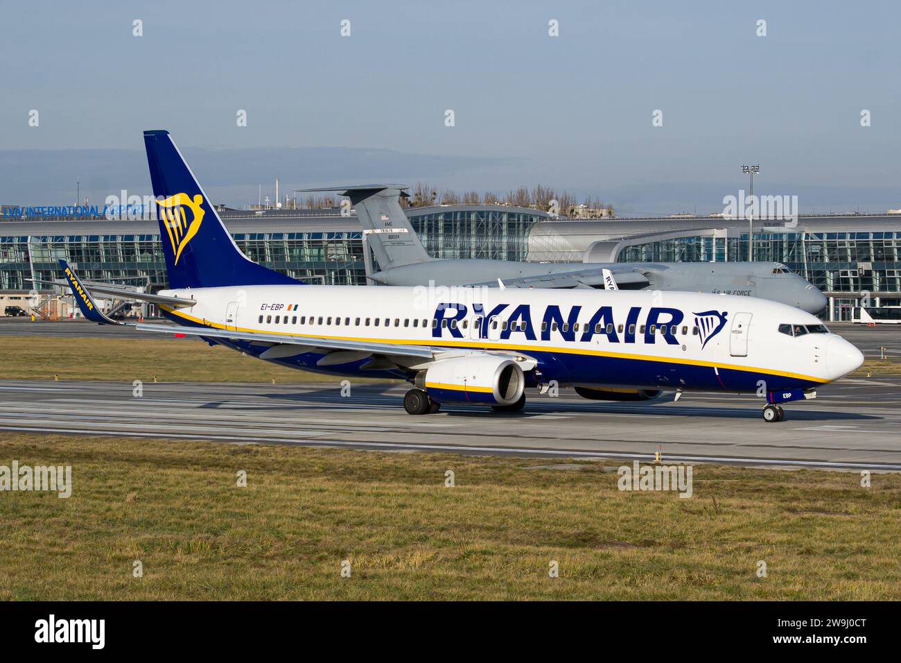 Il Boeing 737-800 della compagnia aerea low-cost irlandese Ryanair è in partenza per il decollo dall'aeroporto di Lviv, con il Lockheed C-5 Galaxy dell'aeronautica americana sullo sfondo Foto Stock