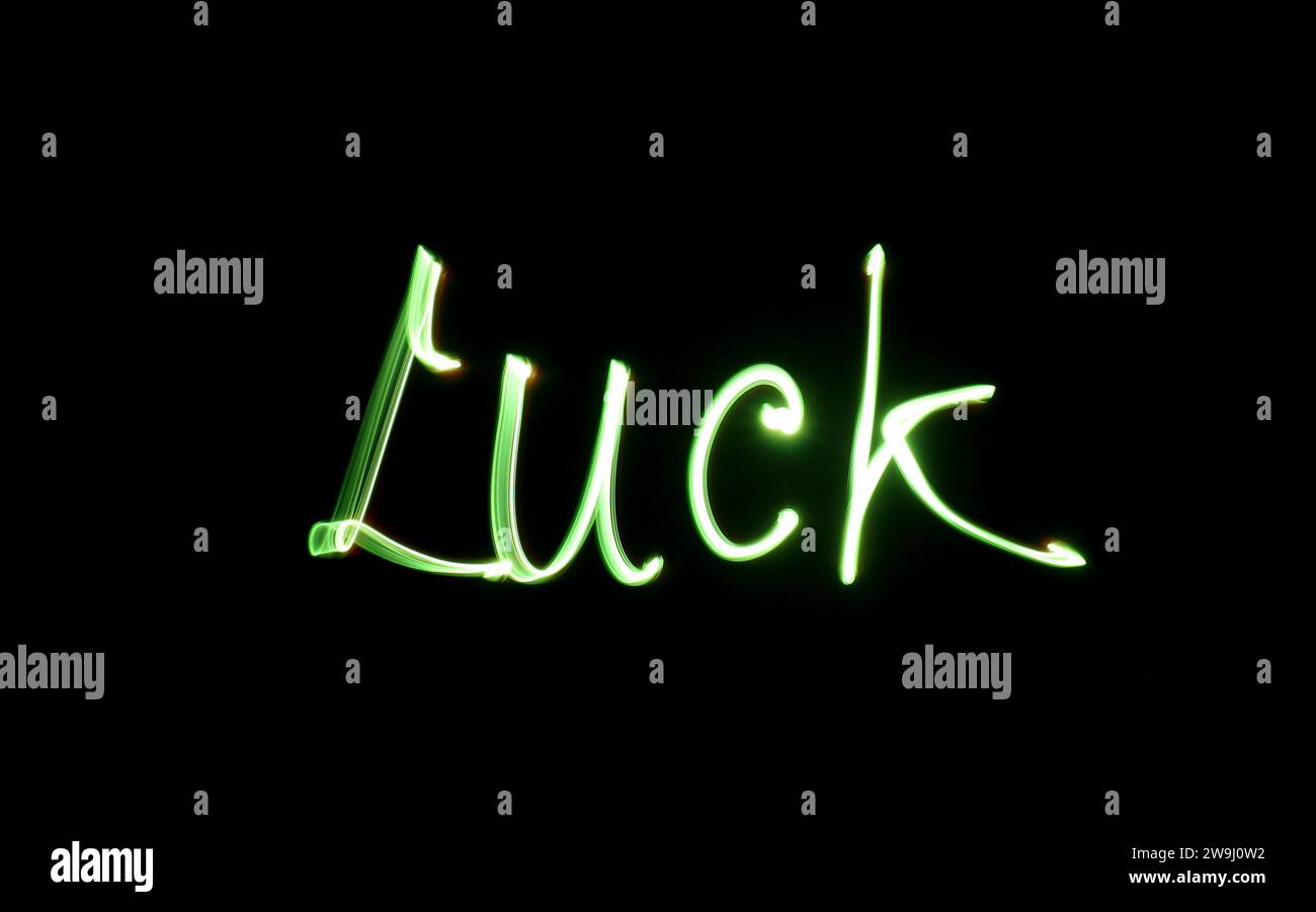 Una fotografia della parola "fortuna" scritta con una luce verde brillante in una foto a lunga esposizione su sfondo nero. Fotografia di pittura leggera Foto Stock