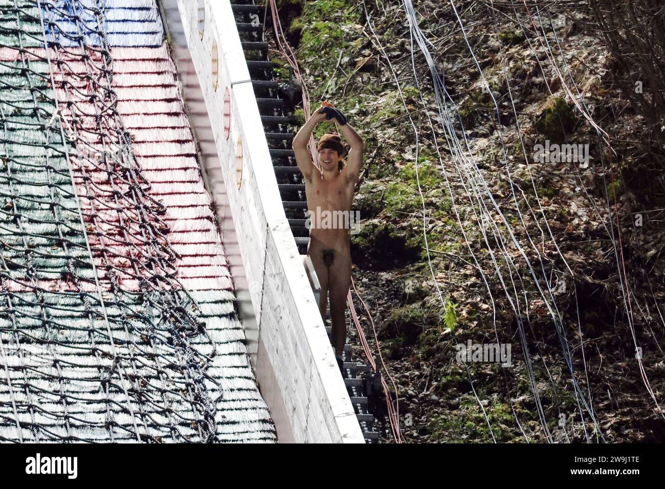 Oberstdorf, Deutschland. 28 dicembre 2023. Ein splitternackter Flitzer sorgte zumindest beim Publikum für Erheiterung bei der Durchquerung des Schanzenauslaufs nach der Qualifikation zum Auftaktspringen der Vierschanzentournee Oberstdorf - und flüchtete dann über den Auslauf der kleinen Schanze Credit: dpa/Alamy Live News Foto Stock