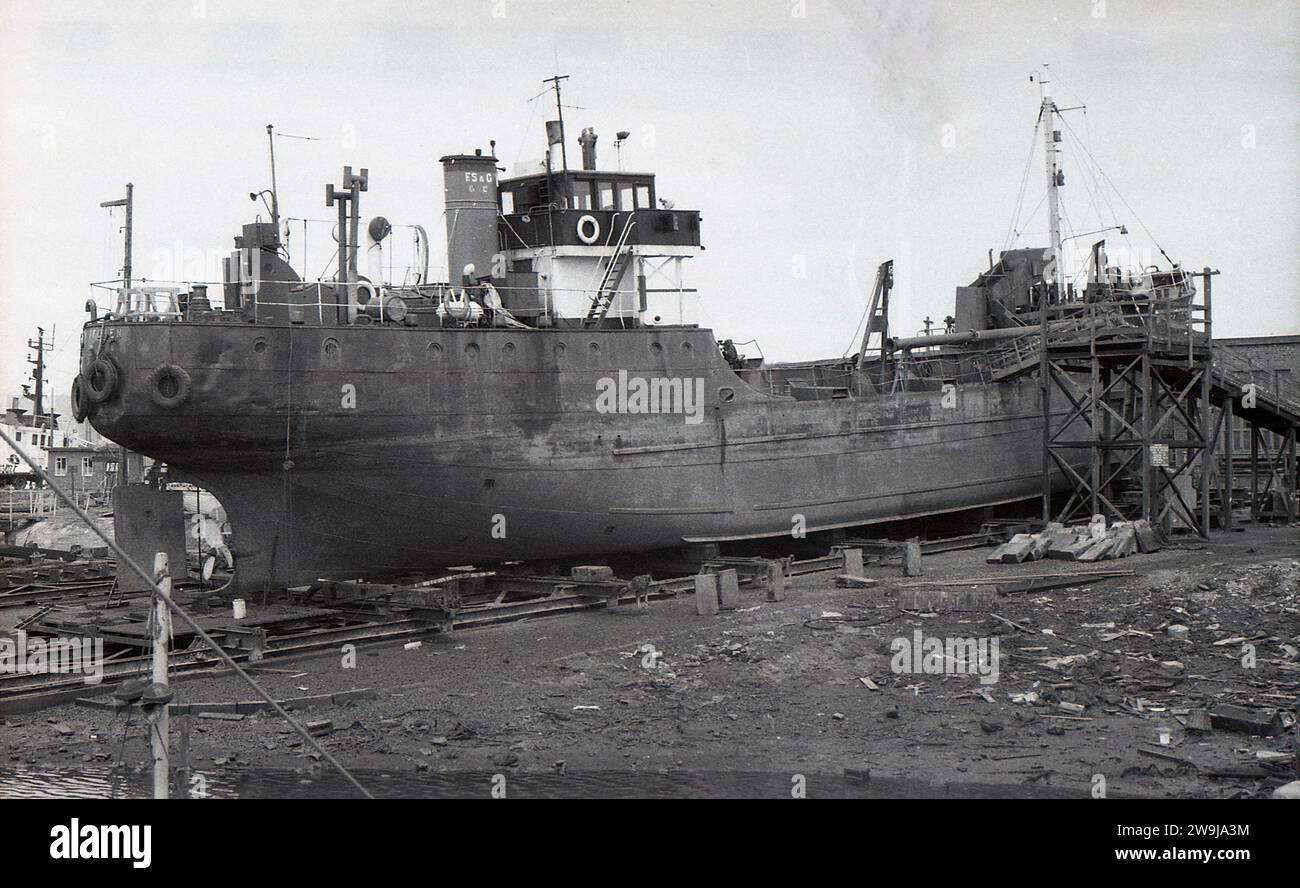 1972, storico peschereccio da traino in bacino di carenaggio, sottoposto a revisione o più probabilmente smantellato per la demolizione, Fleetwood, Lancs, Inghilterra, Regno Unito.la città costiera di Fleetwood nel Borough di Wyre era una volta uno dei più grandi porti di pesca del Regno Unito, con una grande flotta oceanica, ma il declino dell'industria della pesca di Briitsh, inteso dai primi anni '1980, tutti i pescherecci da traino d'altura se ne erano andati. Sconti su imbuto, e S & G.. Foto Stock